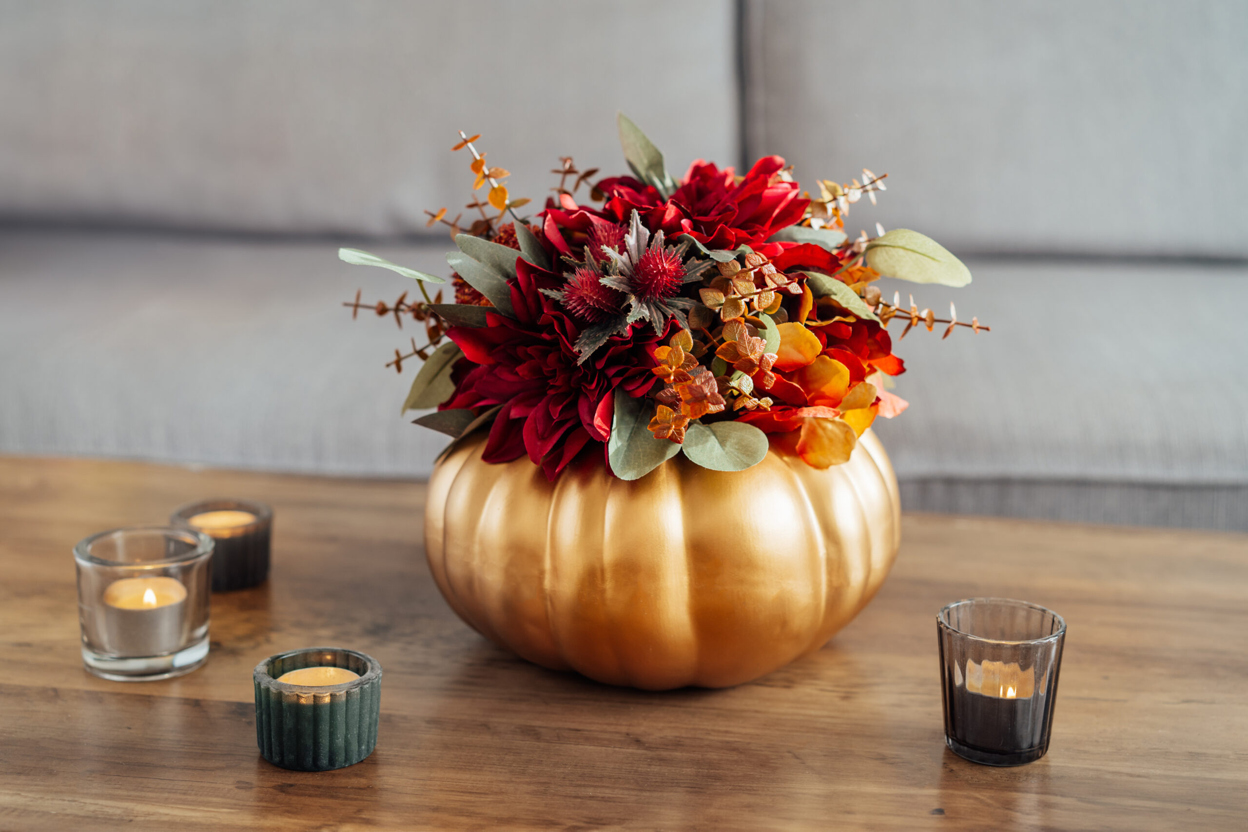 A beautifully arranged golden pumpkin filled with colorful flowers, showcasing a festive seasonal display.